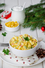 Traditional Russian salad with crab sticks, fresh cucumbers, corn and boiled eggs in a bowl