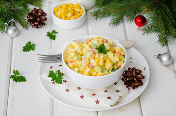 Traditional Russian salad with crab sticks, fresh cucumbers, corn and boiled eggs in a bowl