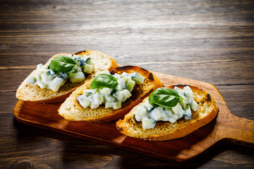 Bruschettas on cutting board on wooden background