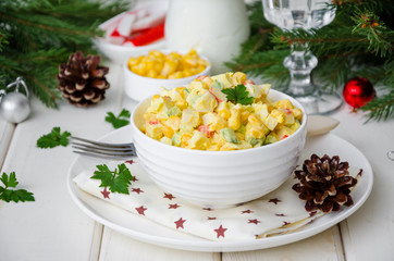 Traditional Russian salad with crab sticks, fresh cucumbers, corn and boiled eggs in a bowl