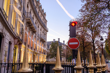 Red traffic lights near a fence with spikes