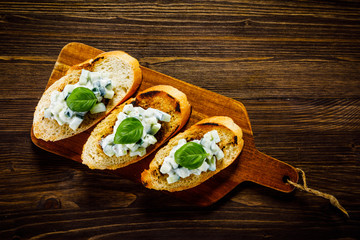 Bruschettas on cutting board on wooden background