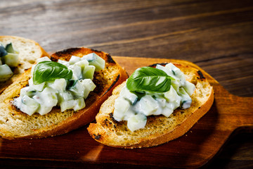 Bruschettas on cutting board on wooden background
