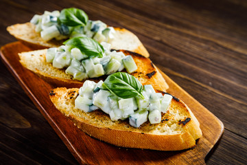 Bruschettas on cutting board on wooden background