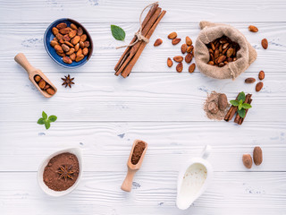 Cocoa powder and cacao beans on wooden background.