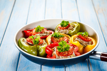 Stuffed peppers in frying pan on wooden table