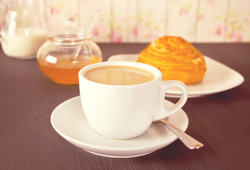 Coffee and cinnabon with honey on the wooden table