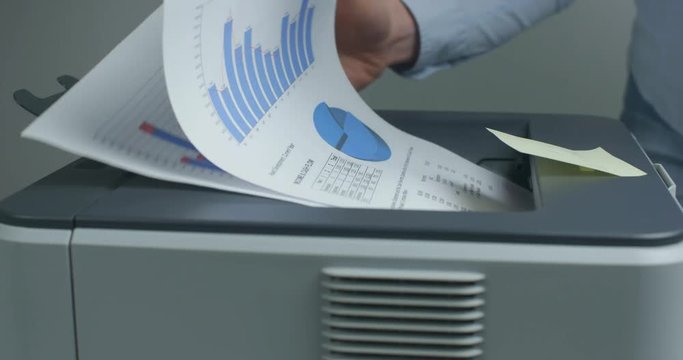 Businesswoman collecting documents from a printer.