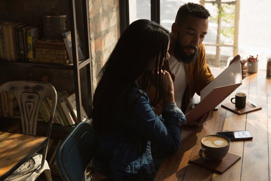 Couple looking at menu in cafe