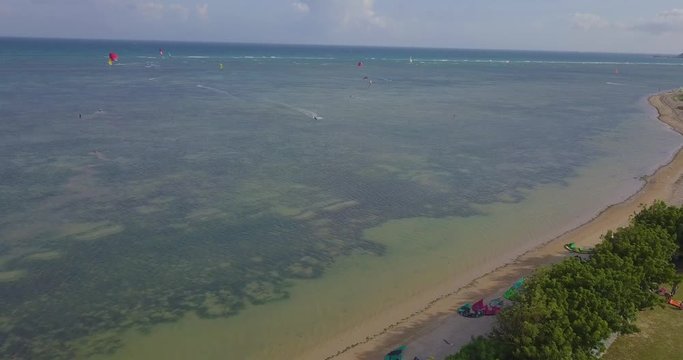 Kiteboarding, kite surf. Extreme sport kitesurfing in tropical blue ocean, clear beach. Aerial views, top view of kitesurfing on the waves of the beautiful sea in Vietnam. Kite surfer rides the waves