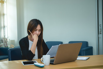 Beautiful asian woman working at the office  in the evening,Thailand worker stress from work,Think idea for new product