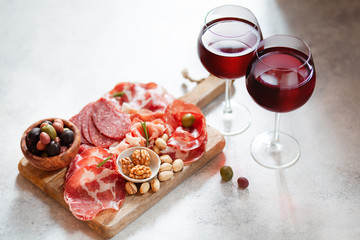 Meat plate, cold smoked pork, jamon, prosciutto, salami served with wine, nuts and olives