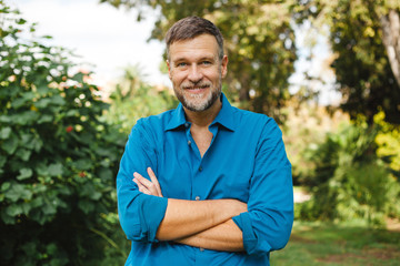 Portrait of Senior man caucasian smiling and looking at camera, outside in park.