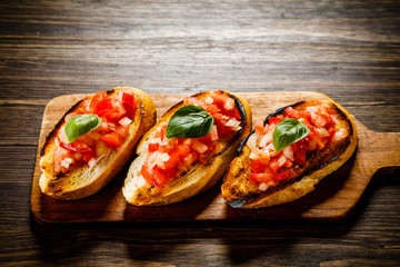 Bruschettas on cutting board on wooden background