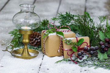 Brown paper packages, lantern and Christmas tree garland on snow y porch