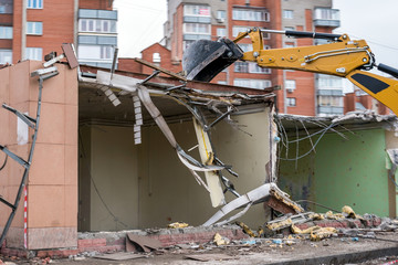 excavator bucket destroys building, demolition of building