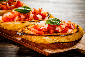 Bruschettas on cutting board on wooden background