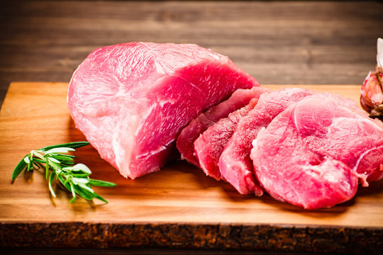 Fresh raw beef steaks on wooden background
