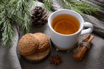 Cup of lemon tea cookies cinnamon fir branch Winter holidays concept Cozy home
