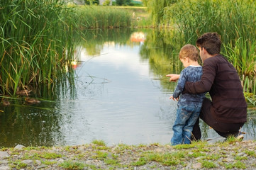 Two brothers - one teenager, and the other still goes to the garden, walk around the lake and look at the ducks