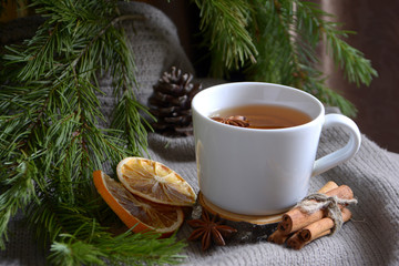 Obraz na płótnie Canvas Cup of lemon tea dried oranges cinnamon fir branch Winter holidays concept Cozy home