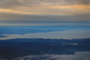 Fototapeta na wymiar view from the plane to the island of Sakhalin, the mountains and the sea with the seaport