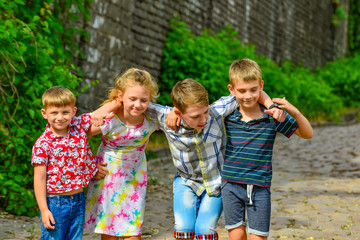 Four happy and joyful children are embracing each other, brothers and sisters together.