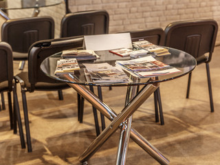 Glass table with many leaflets over at a fair