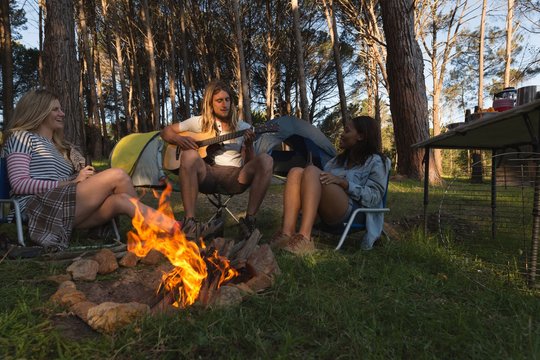 Group of friends having fun near bonfire