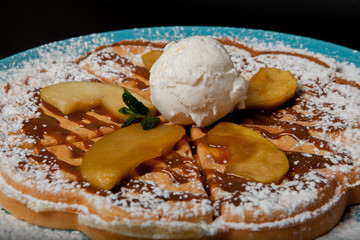 Chopped caramelized apples for breakfast on a black background