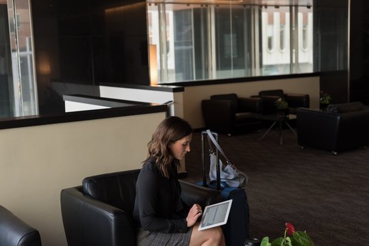 Businesswoman using digital tablet in lobby