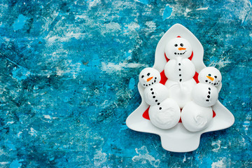 Funny meringue snowman food art idea for kids New Year and Christmas background