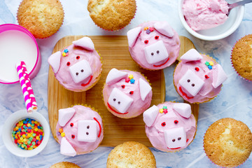 Pig cupcakes - homemade cakes shaped funny piggies decorated with pink cream and marshmallow, new...