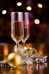 New Years Eve celebration background with pair of flute,candles forming the 2019 number, glitter and defocused background, with christmas tree light forming a nice bokeh, holiday concept, frontal view