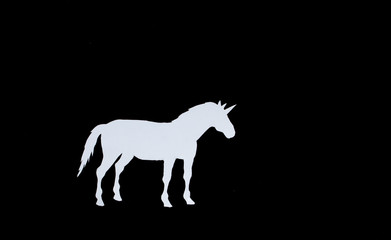 Naklejka na ściany i meble White unicorn with paper on a black background