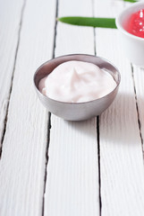 beauty and cosmetic creams with pink flowers on white wood