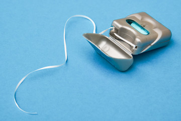 Dental floss on a blue background with copy space