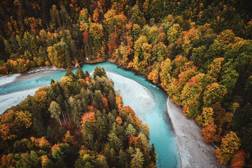 Luftbild eines Flusses mit Sandbank und Geröll im Herbst in den Alpen