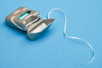 Dental floss on a blue background with copy space