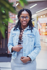 Young dark-skinned woman dressed in casual clothes in the mall
