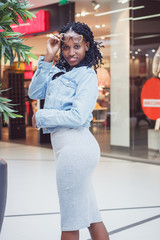 Young dark-skinned woman dressed in casual clothes in the mall