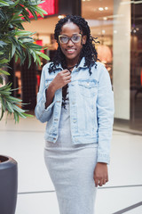 Young dark-skinned woman dressed in casual clothes in the mall