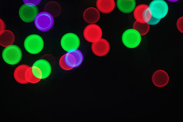 Color bokeh circles blurred on black background.