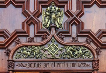 Inscription Domus Dei et Porta Coeli meaning House of God, and Door to Heaven on the wooden entrance to Cathedral of the Holy Cross and Saint Eulalia, or Barcelona Cathedral in Spain
