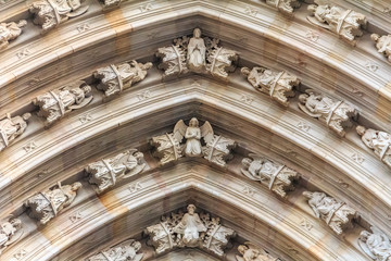 Gothic detail of cherubs on the facade above the main gate of Cathedral of the Holy Cross and Saint Eulalia, or Barcelona Cathedral in Barcelona, Spain