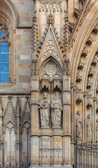 Fototapeta na wymiar Gothic detail of the sculptures on the facade and tracery of Cathedral of the Holy Cross and Saint Eulalia, or Barcelona Cathedral at sunset in Barcelona, Spain