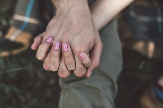 Take a break and relax together. Top view close up portrait of young man and woman in love holding hands