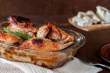 Baked turkey with potatoes in a glass dish on a wooden table. Thanksgiving Day