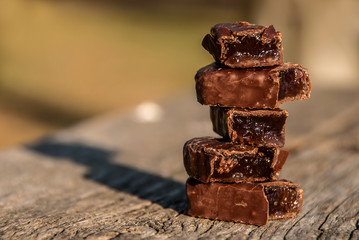 Stack of chocolates on old wooden bench. Valentines day background, greeting, invitation card, wedding.