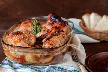Baked turkey with potatoes in a glass dish on a wooden table. Thanksgiving Day